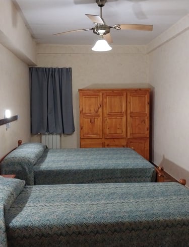 Una habitación con una cama matrimonial y otra cama individual