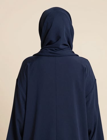 A cozy, inviting corner with folded mastour clothing pieces arranged neatly on shelves.