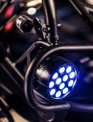 A round blue LED stage light mounted on a black metal rigging frame for professional event lighting.