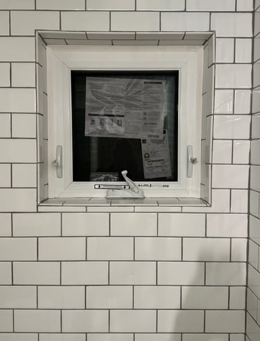 a bathroom window with a window in the middle of it