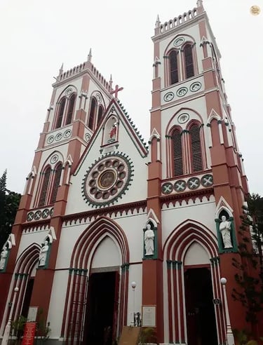 Exterior of the Sacred Heart Basilica in Pondicherry with red-and-white Gothic design.