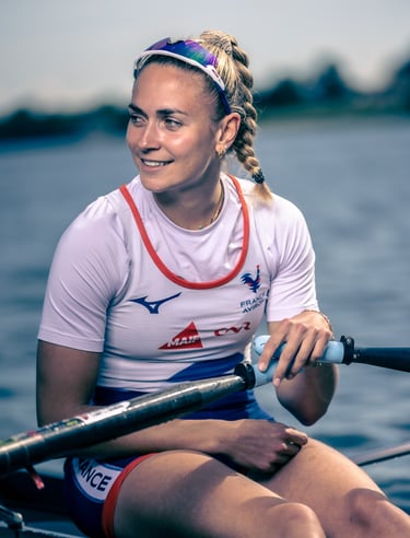 Portrait d’une athlète assise dans un skiff, regard tourné vers la droite.