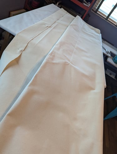 10 oz linen folded and laid on a large artist's table for folding and pinning., 