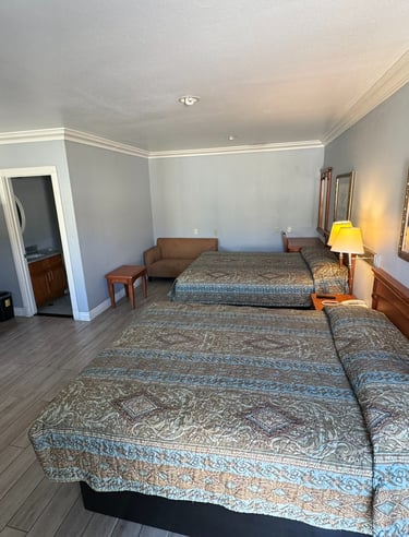 a motel room with two beds and a couch
