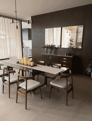 Comedor contemporáneo con muro de madera oscura, velas decorativas y espejo | KARÄNA