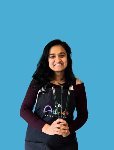 Vyoma in a apron holding a paintbrush