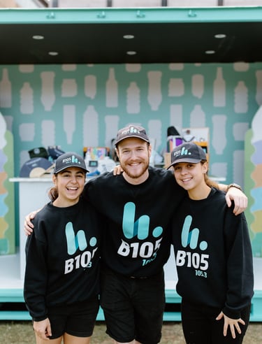 three people standing in front of a large containers for change stand