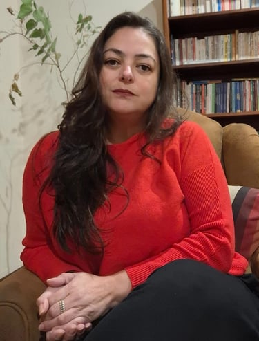 Psicóloga Marcia Lhamas em seu espaço de atendimento online, cercada por plantas e livros, em atmosf