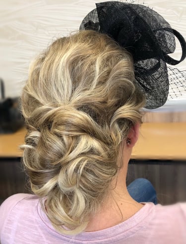 a woman with a veiled headpiece on her head displaying hairstyling for a wedding