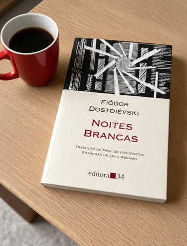 Portuguese edition of White Nights by Fyodor Dostoevsky on a wooden table next to a red coffee mug.