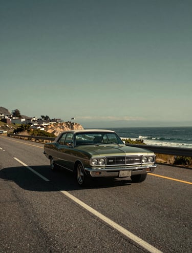 Cinematic travel photography of a vintage car driving along a coastal North American / US highway, artistic perspective, warm afternoon sun, Dark Charcoal and Olive Green tones.