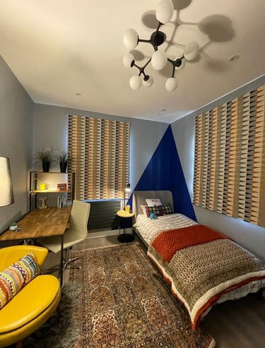 Teen bedroom with single bed, colour block, Harlequin blind, accent chair, study table, storage, rug