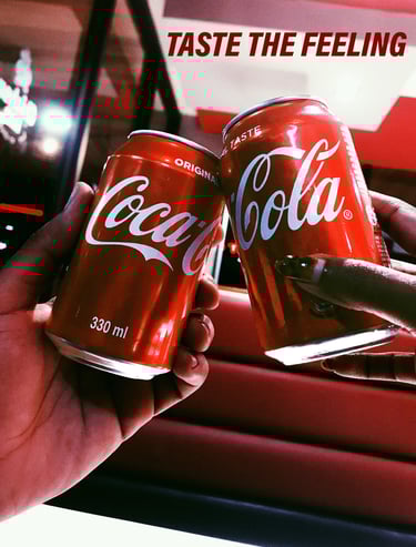 Two hands clink red Coca-Cola cans together in a celebratory gesture 