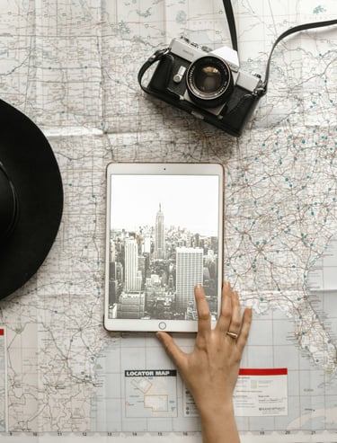 Ipad y teléfono sobre mapa haciendo referencia a planeación de viajes