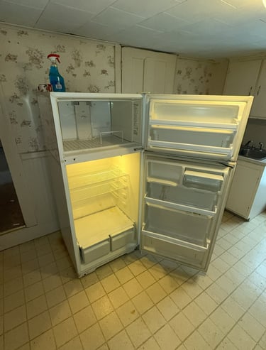 Heavy refrigerator being carried out during appliance removal service