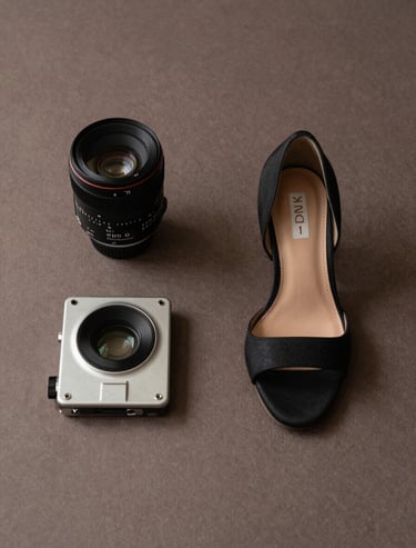 An artistic editorial photography shot of high-fashion accessories on a muted brown textured surface, minimalist and refined, North American / European aesthetic.