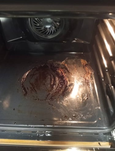 “Restos de comida quemada y manchas de grasa en el fondo de un horno eléctrico sucio