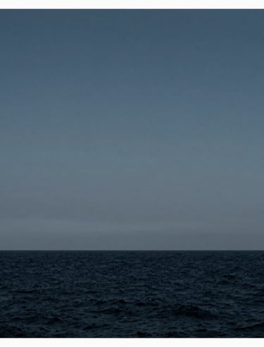 A minimalist composition of a distant horizon line between a dark navy sea and a steel blue grey sky, clean and serene, International / Western.
