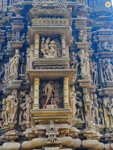 Detailed carvings on the outer wall of Vamana Temple Khajuraho showing daily life scenes.