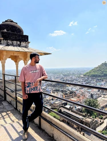 Traveler overlooking the blue city of Bundi from Garh Palace, capturing the panoramic view below.