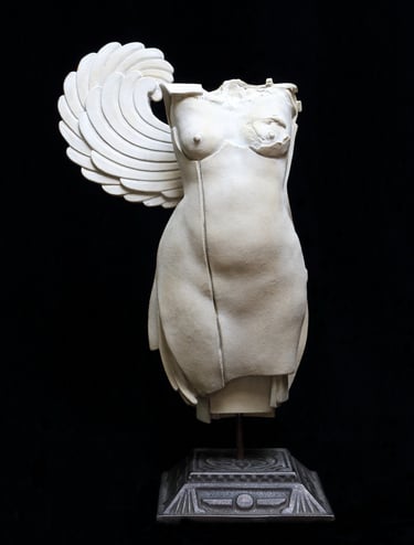 Small ceramic fragment of a female figure with a single wing and one disfigured breast.