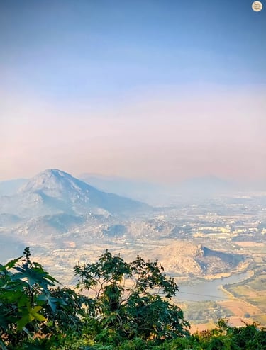 View of Skandagiri peak from the Gandhi Nilaya viewpoint at Nandi Hills, overlooking misty valleys and surrounding hills