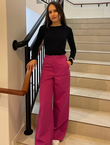 Mulher usando uma calça pantalona rosa e blusa preta