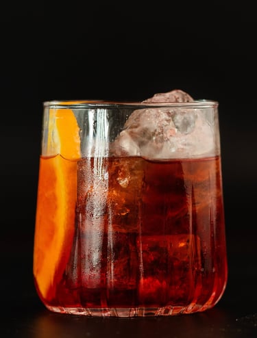 Ein perfekt angerichteter Negroni-Cocktail in einem edlen Kristallglas, hervorgehoben durch kristall