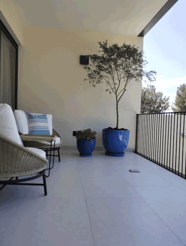 Terraza acogedora con sillones y plantas decorativas en macetas azules | KARÄNA