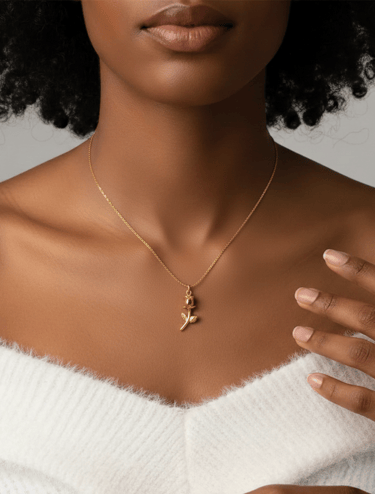 Elegant gold rose pendant necklace worn by a woman in a white sweater.