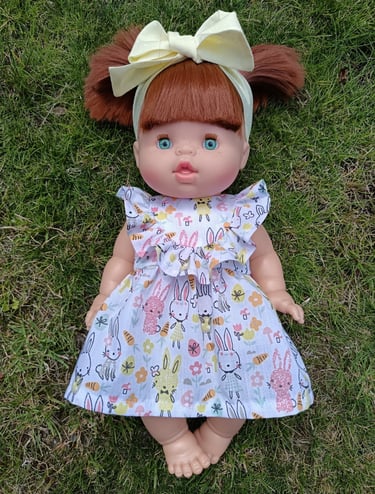 Minikane doll Gabrielle dressed in a ruffled dress with a bow headband