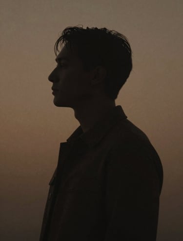 Cinematic photography of a human silhouette against a muted bronze light. Minimalist composition with soft charcoal shadows and a sophisticated, intimate mood.