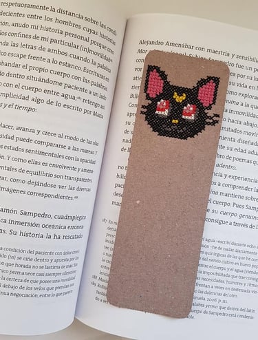 Un separador de libro bordado a mano en punto de cruz sobre un libro