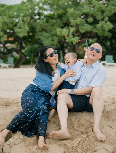 Family sitting together on the beach enjoying a relaxed afternoon at Nusa Dua Beach Bali