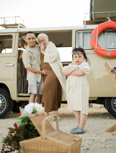 Lifestyle family portrait beside a vintage combi van at Melasti Beach Bali during sunset