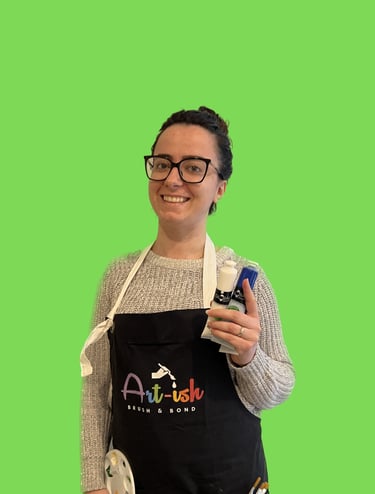 Nour in a apron holding a paintbrush