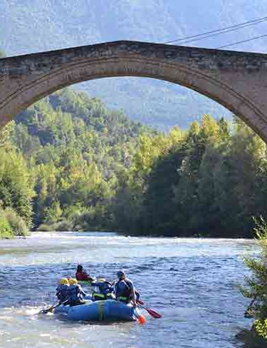 a group of people rafting down a river in sort