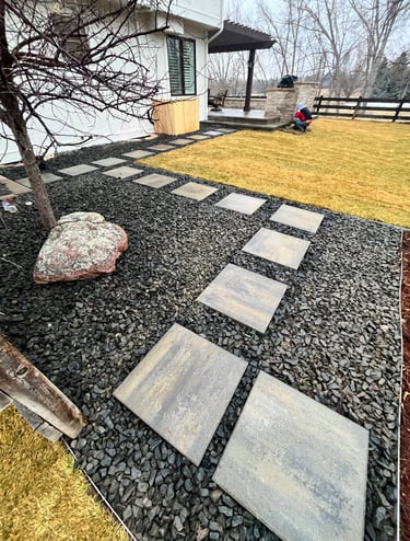 BlueMoon Pathway leading toward Patio- 1 1/2 inch black Granite rock surrounding pathway.