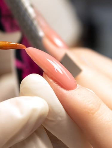 a person is holding a nail brush and is forming acrylic nails