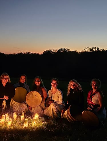 a group of women sitting around a candles at night
