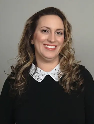 middle aged latin female smiling wearing black blouse white pearl trim