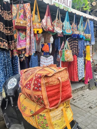 Handcrafted bandhej and leheriya printed cloths and bags displayed in a Udaipur Surajpole bazar.