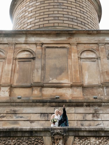 a bride and groom standing on a balcony
