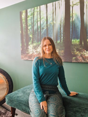 Chrissy sitting on a treatment couch in her studio