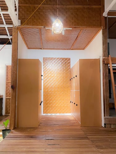 Rustic bamboo locker room interior with woven textures and warm hanging pendant light.
