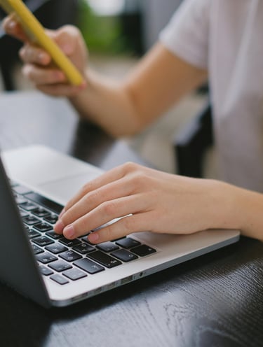 Agente de viajes buscando opciones de viajes personalizados en laptop y teléfono