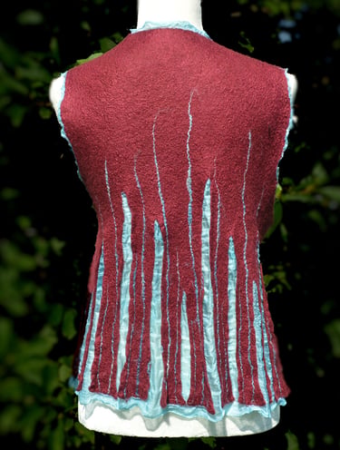 Handmade burgundy nuno felted wool vest with light green silk accents on a mannequin.