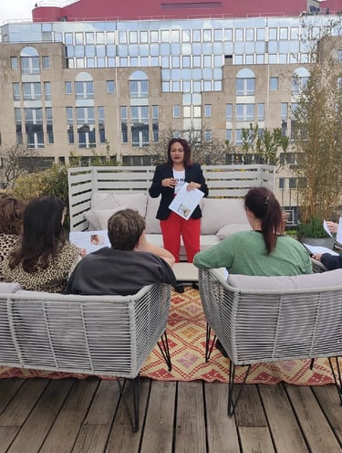 Groupe d’élèves assis sur une terrasse, suivant une formation dirigée par une formatrice.