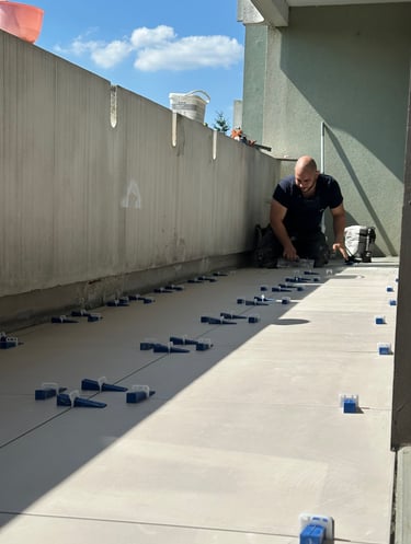 Travailleurs réalisant une pose de carrelage sur un balcon