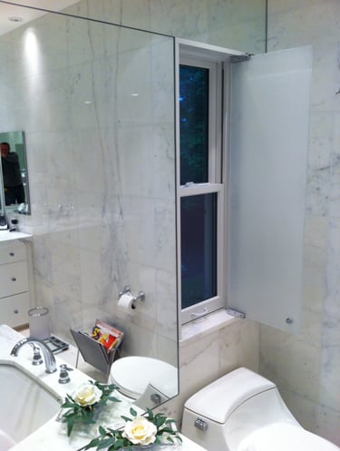 Modern luxury bathroom with white marble walls, a bathtub, and an integrated privacy window shutter.